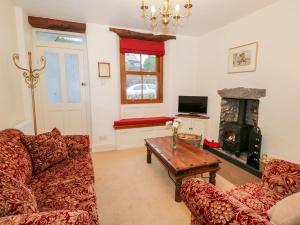 a living room with a couch and a fireplace at 3 School View in Ulverston