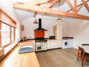 a kitchen with a stove and a stove top oven at Honey Buzzard Barn in Fakenham