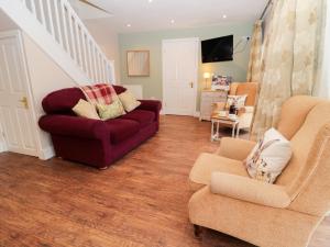uma sala de estar com um sofá vermelho e duas cadeiras em Granary Barn em Gateshead