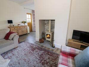 a living room with a couch and a fireplace at Chalk Cottage in Great Malvern