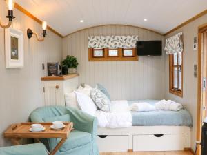 a bedroom with a bed and a couch and a table at Little Silver Leaf in High Bickington