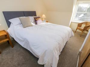 1 cama blanca grande en una habitación con ventana en Fois House, en Aberfoyle