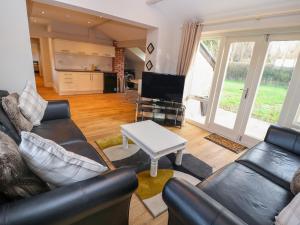 a living room with a couch and a table at Commonwood Cottage in Wrexham