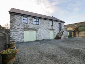 a stone house with two garage doors and some plants at The Granary in Holyhead