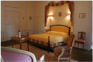 a bedroom with a bed and a table and chairs at Le Chateau de Prauthoy in Prauthoy