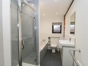 a bathroom with a shower and a toilet and a sink at The Stable in York +9 photos