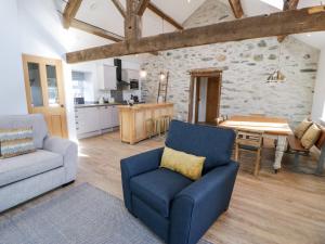 a living room with a blue chair and a table at The Granary in Holyhead