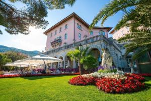 a large pink building with flowers in front of it at Amadria Park Hotel Milenij in Opatija