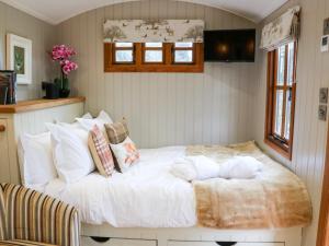 um quarto com uma cama com lençóis brancos e almofadas em Little Silver Fox em High Bickington