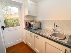 a kitchen with a sink and a microwave at Linden Cottage in Smardale