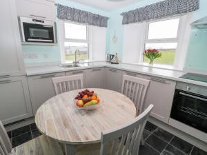 a kitchen with a table with a bowl of fruit on it at Birds Nest in Oxnam
