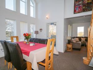 a dining room with a table and chairs and a living room at The Beeches in Forres