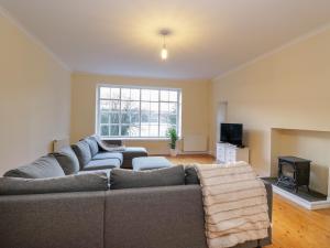 a living room with a couch and a tv at Rosemount Cottage in Helensburgh