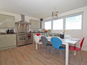 a kitchen with a white table and chairs at Seagrass in Newquay +16 photos