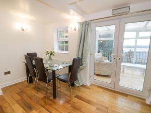 a dining room with a glass table and chairs at Preswylfa Apartment in Caernarfon