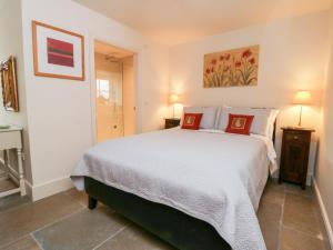 a bedroom with a large white bed with red pillows at Wallerthwaite Barn Cottage in Harrogate