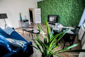 - un salon avec un canapé bleu et une table dans l'établissement 4YOU APARTMENT, à Toruń