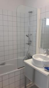 uma casa de banho branca com um lavatório e um chuveiro em LOU CIGALOU em Cassis