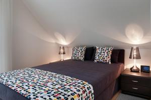 a bedroom with a bed with two lamps on it at Domki Wioska Rybacka in Hel