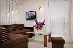 a living room with a couch and a table with flowers at Domki Wioska Rybacka in Hel