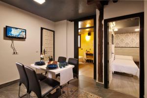 uma sala de jantar com uma mesa e cadeiras e uma cama em Apartamentos El Tiempo Madrid em Madri