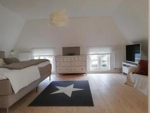 ein Schlafzimmer mit Bett, Kommode und Fernseher in der Unterkunft Haus Friedrichsen in Hollingstedt