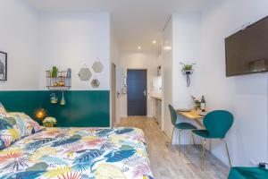 a bedroom with a bed and a table with chairs at Les Cocons Emeraude et Fleuri in Lyon +29 photos