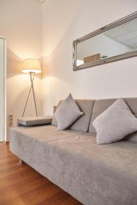 a couch in a room with a lamp and a mirror at Modern Apartment suitable for Longstays in Vienna