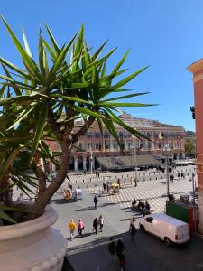 een groep mensen die rond een plein lopen met een palmboom bij Hyper Centre Place Massena in Nice
