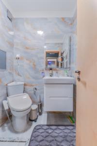 ein Badezimmer mit Toilette und Waschbecken in der Unterkunft The Spot - fully equipped, central, modern studio by Flat Mаnager in Sofia