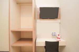 a room with a desk and a tv on a shelf at Bumi Banyu Bening Syariah by ecommerceloka in Surabaya