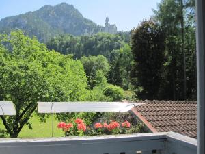 een uitzicht vanaf het balkon van een huis met bloemen bij Romantic-Pension Albrecht - since 1901 in Hohenschwangau