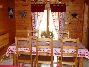 a dining room with a table and chairs and a window at Chalet Les Sapins Argentés in Gérardmer