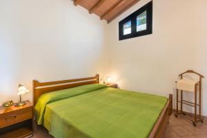 - une chambre avec un lit vert et une fenêtre dans l'établissement Appartamenti Bellavista by HelloElba, à Portoferraio
