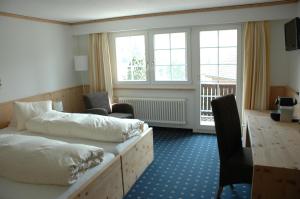 a hotel room with two beds and a desk at Landgasthof Sternen in Bühler