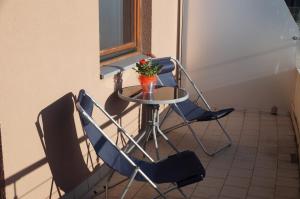a table with two chairs and a vase of flowers at Nadmorski Apartament in Hel