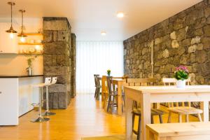 a kitchen and dining room with a stone wall at Casa dos Caldeiras in Lajes do Pico