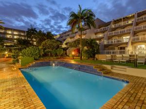 a swimming pool in front of a building at Umhlanga Cabanas in Durban