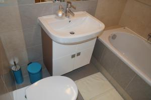 a bathroom with a white sink and a toilet at Nadmorski Apartament in Hel