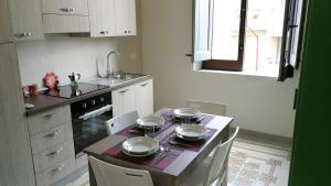 a kitchen with a table with plates and pans on it at Residenza 1930 in Castellammare del Golfo