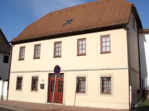 a white building with a brown roof at Ferienwohnung Eckoldt in Eisenberg