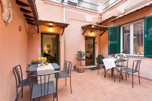 a patio with tables and chairs on a patio at Green Apartments Rome in Rome