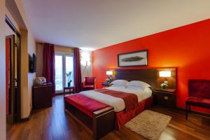 a hotel room with a bed and a red wall at Hotel de Berny in Antony