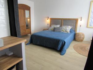 um quarto com uma cama com uma colcha azul em Les Bordes em Vineuil