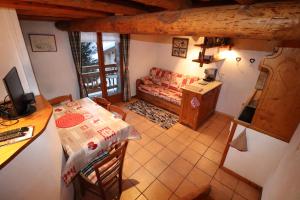 eine Küche und ein Wohnzimmer mit einem Tisch und einem Sofa in der Unterkunft Appartement cosy pour 4 personnes en chalet de pierres in Saint-Martin-de-Belleville
