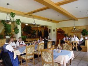 eine Gruppe von Personen, die in einem Restaurant an Tischen sitzen in der Unterkunft Gasthof zum Kaiserweg in Schladming