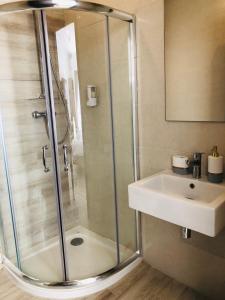 a bathroom with a shower and a sink at Napoli Suites Studios Aparthotel in St Julian's