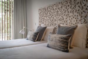 a bedroom with a bed with two pillows on it at Pestana Troia Eco-Resort & Residences in Troia