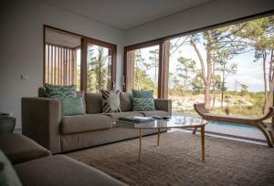 a living room with a couch and a glass table at Pestana Troia Eco-Resort & Residences in Troia