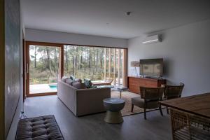 a living room with a couch and a television at Pestana Troia Eco-Resort & Residences in Troia